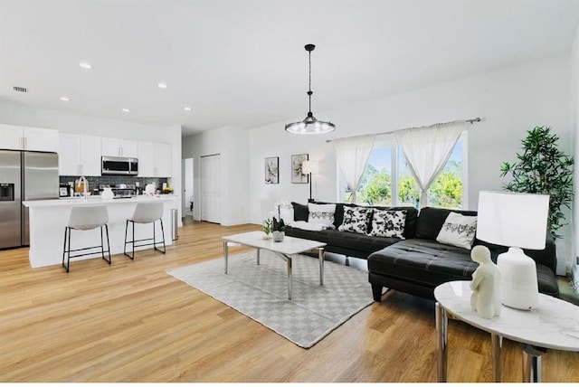 living room with light hardwood / wood-style flooring and a chandelier