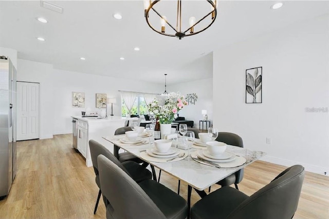 dining area featuring light hardwood / wood-style flooring and an inviting chandelier