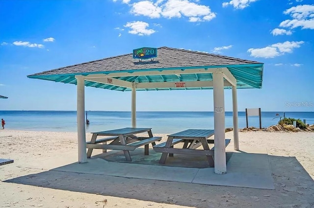 surrounding community with a beach view, a gazebo, and a water view