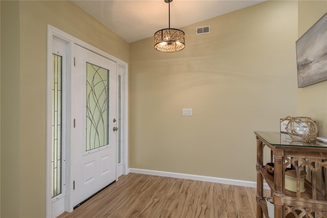 4514 Dewey Dr, New Port Richey, FL 34652 - foyer entrance with light wood-type flooring, baseboards, and a chandelier