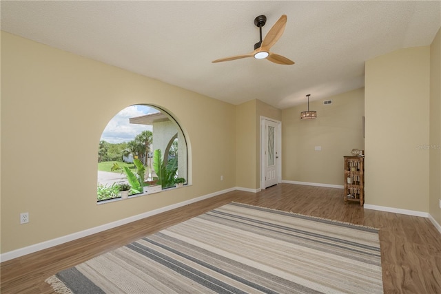 4514 Dewey Dr, New Port Richey, FL 34652 - spare room featuring wood finished floors, a ceiling fan, baseboards, and vaulted ceiling