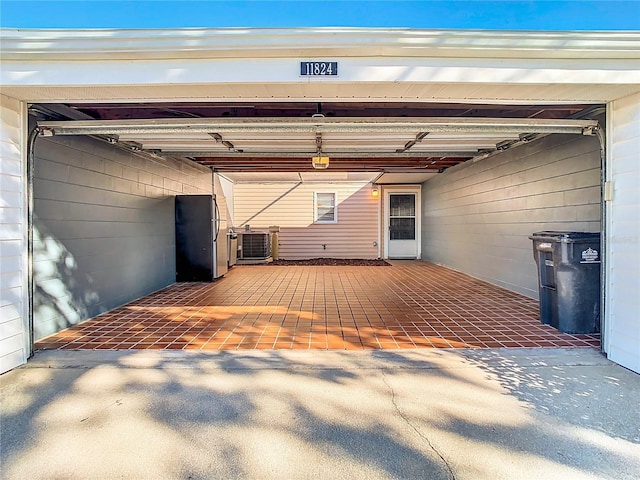 garage featuring cooling unit and stainless steel refrigerator