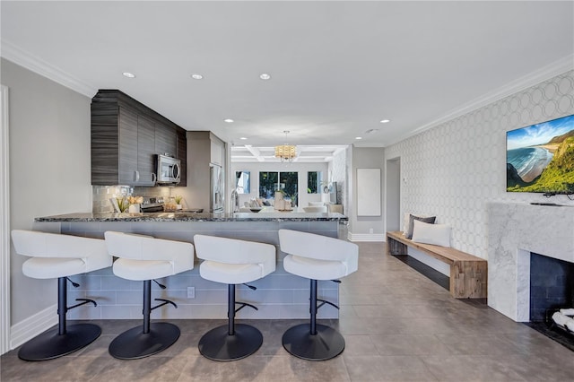 kitchen with a kitchen bar, kitchen peninsula, and crown molding