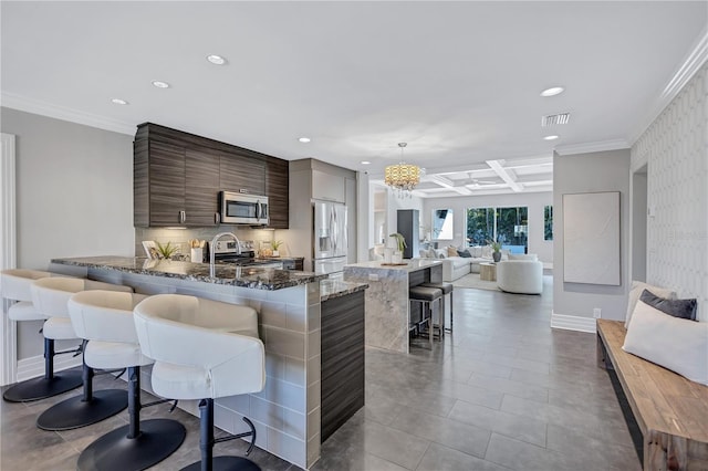 kitchen with kitchen peninsula, coffered ceiling, a breakfast bar, dark brown cabinets, and stainless steel appliances