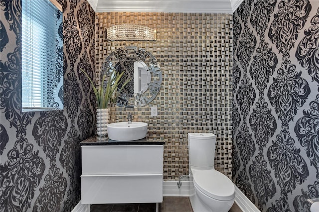 bathroom with tile patterned floors, crown molding, vanity, and toilet