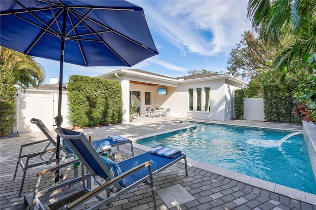 view of swimming pool featuring ceiling fan, pool water feature, and a patio