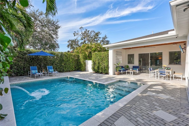 view of swimming pool featuring ceiling fan and a patio area