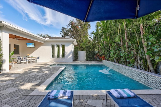 view of pool with pool water feature, a patio, and ceiling fan