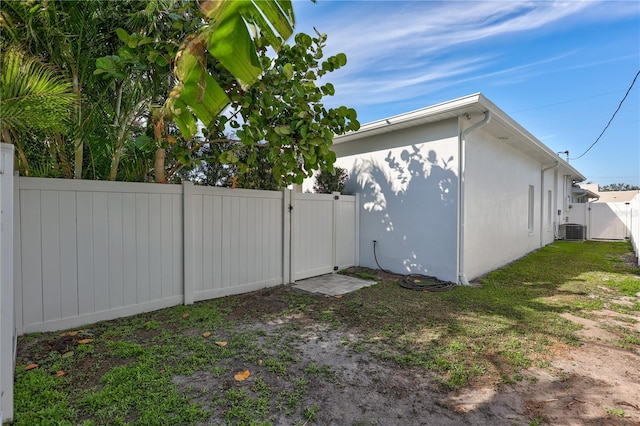 view of side of home with a lawn and central AC unit