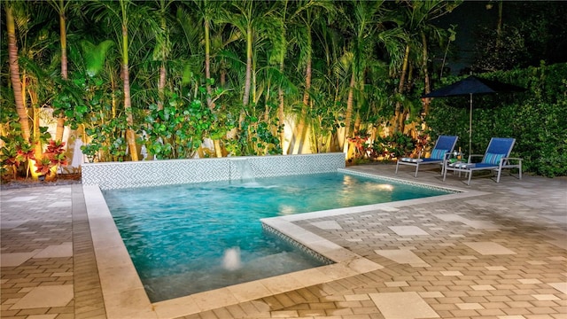 view of swimming pool featuring pool water feature and a patio