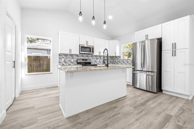 kitchen featuring light stone countertops, an island with sink, pendant lighting, white cabinets, and appliances with stainless steel finishes