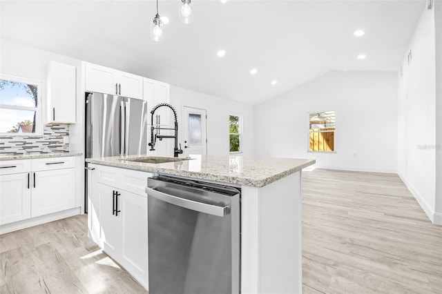 kitchen featuring a kitchen island with sink, white cabinets, sink, vaulted ceiling, and appliances with stainless steel finishes