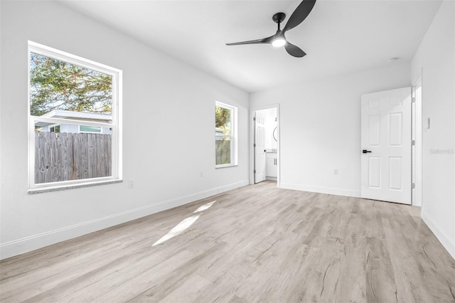 empty room with a wealth of natural light, ceiling fan, and light hardwood / wood-style floors