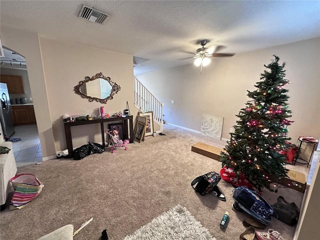 interior space featuring ceiling fan, carpet floors, and a textured ceiling