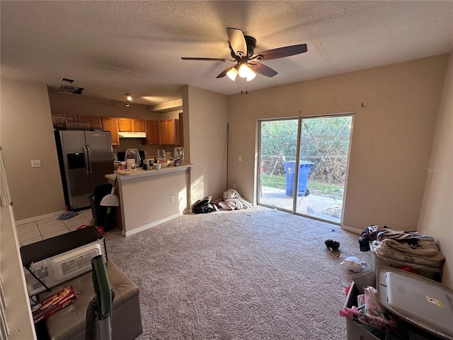 living room with ceiling fan, light carpet, and a textured ceiling