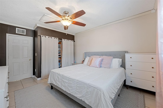 tiled bedroom with a textured ceiling, ceiling fan, and ornamental molding