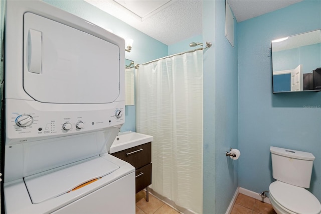 washroom with stacked washer and clothes dryer, light tile patterned flooring, and a textured ceiling