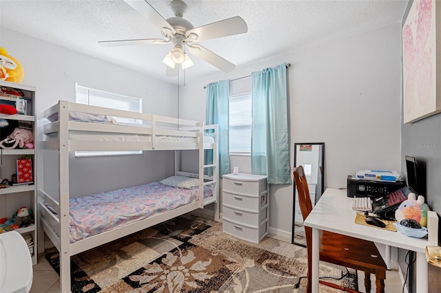 bedroom featuring ceiling fan, multiple windows, and a textured ceiling