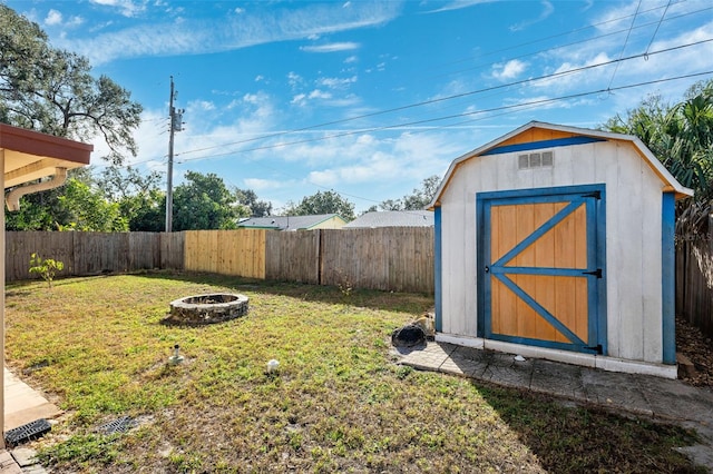 view of yard with an outdoor fire pit and a storage unit