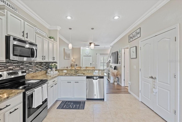 kitchen with kitchen peninsula, appliances with stainless steel finishes, ceiling fan, sink, and white cabinets