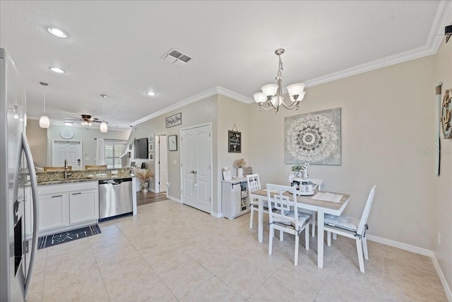 dining area with sink, light tile patterned floors, ceiling fan with notable chandelier, and ornamental molding