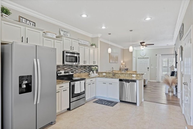 kitchen featuring ceiling fan, light stone countertops, appliances with stainless steel finishes, decorative light fixtures, and kitchen peninsula