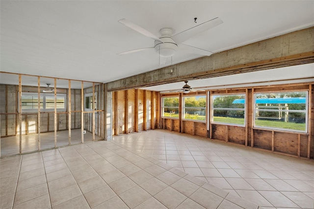 unfurnished sunroom featuring ceiling fan