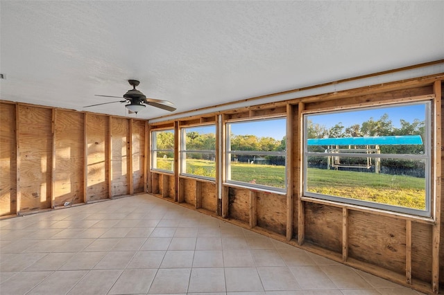 unfurnished sunroom with ceiling fan