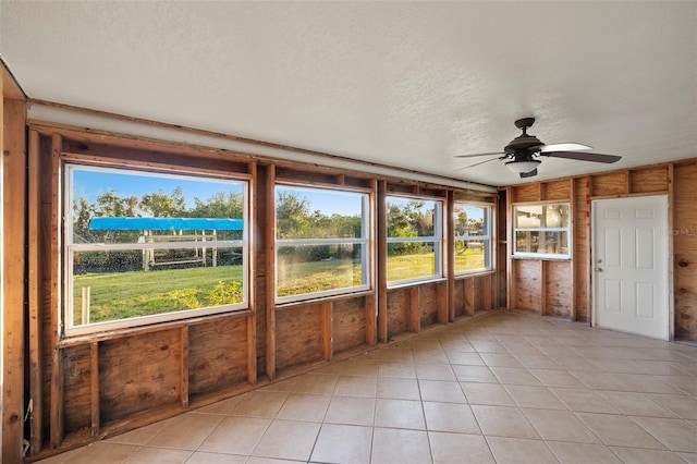 unfurnished sunroom with ceiling fan