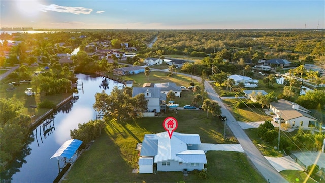 aerial view at dusk featuring a water view