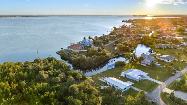 aerial view at dusk featuring a water view