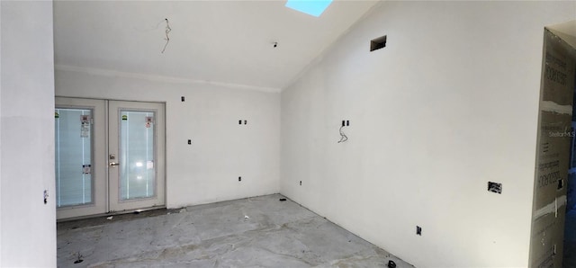 unfurnished room featuring french doors, lofted ceiling with skylight, and a wealth of natural light