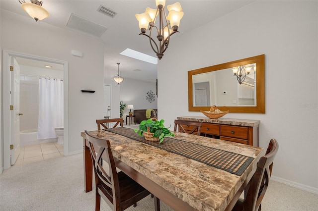 carpeted dining area featuring a chandelier