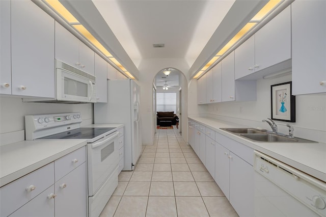 kitchen with sink, light tile patterned floors, white cabinets, and white appliances