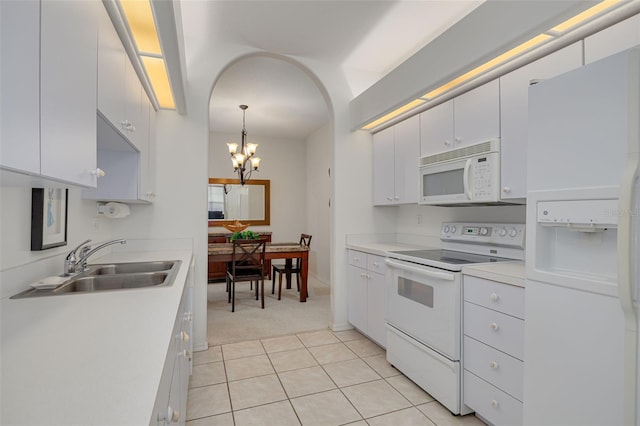 kitchen with white cabinetry, white appliances, pendant lighting, and a chandelier