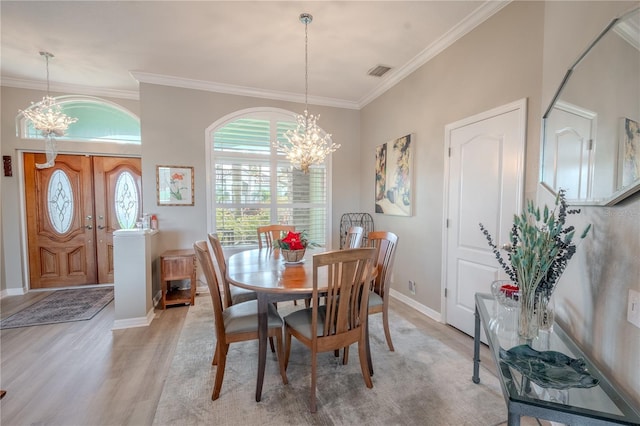 12113 Marblehead Dr, Tampa, FL 33626 - dining space featuring a chandelier, light wood finished floors, crown molding, and baseboards