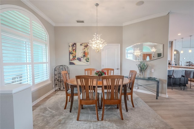 12113 Marblehead Dr, Tampa, FL 33626 - dining area featuring a chandelier, light wood-style flooring, baseboards, and ornamental molding