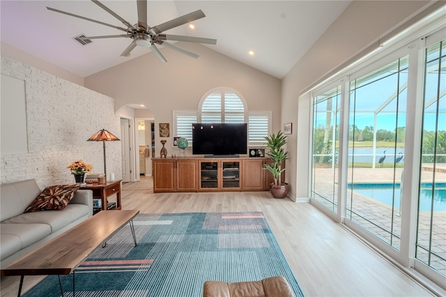 12113 Marblehead Dr, Tampa, FL 33626 - living area featuring high vaulted ceiling, light wood-style flooring, ceiling fan, arched walkways, and recessed lighting