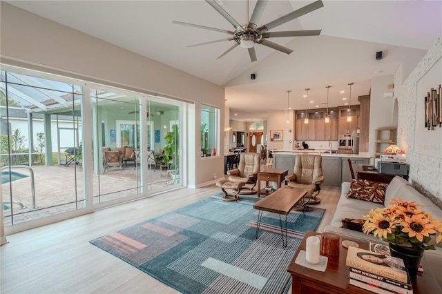 12113 Marblehead Dr, Tampa, FL 33626 - living room with a ceiling fan, light wood finished floors, a sunroom, and high vaulted ceiling