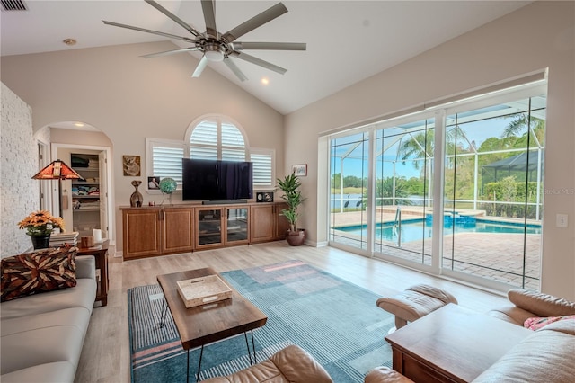 12113 Marblehead Dr, Tampa, FL 33626 - living room featuring ceiling fan, high vaulted ceiling, light wood finished floors, arched walkways, and recessed lighting
