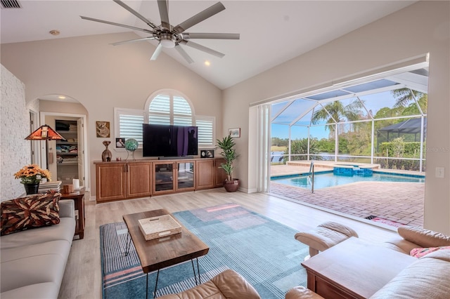 12113 Marblehead Dr, Tampa, FL 33626 - living area with a sunroom, a ceiling fan, high vaulted ceiling, light wood-type flooring, and arched walkways