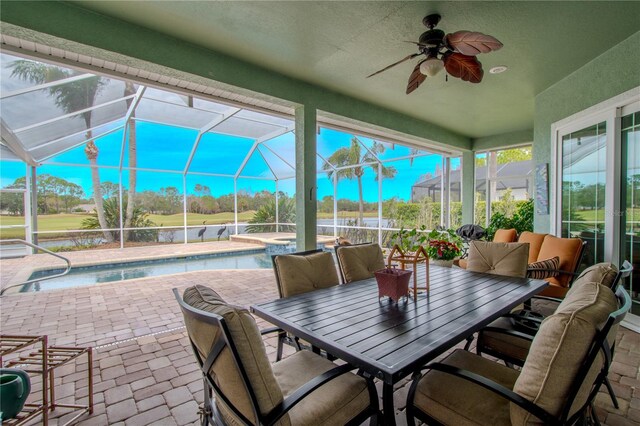 12113 Marblehead Dr, Tampa, FL 33626 - view of patio / terrace featuring glass enclosure, a ceiling fan, a pool with connected hot tub, and outdoor dining space