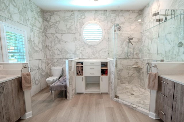 12113 Marblehead Dr, Tampa, FL 33626 - full bath featuring a marble finish shower, vanity, wood finished floors, healthy amount of natural light, and tile walls