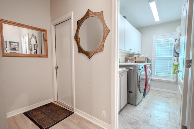 12113 Marblehead Dr, Tampa, FL 33626 - laundry area with cabinet space, washer and clothes dryer, and baseboards
