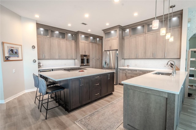 12113 Marblehead Dr, Tampa, FL 33626 - kitchen with stainless steel appliances, a breakfast bar area, light wood-type flooring, a sink, and recessed lighting