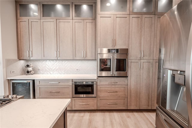 12113 Marblehead Dr, Tampa, FL 33626 - kitchen with appliances with stainless steel finishes, beverage cooler, light wood-style floors, decorative backsplash, and light stone countertops