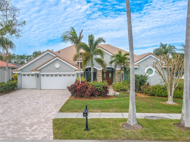 12113 Marblehead Dr, Tampa, FL 33626 - view of front of property with decorative driveway, a front yard, a tile roof, and a garage
