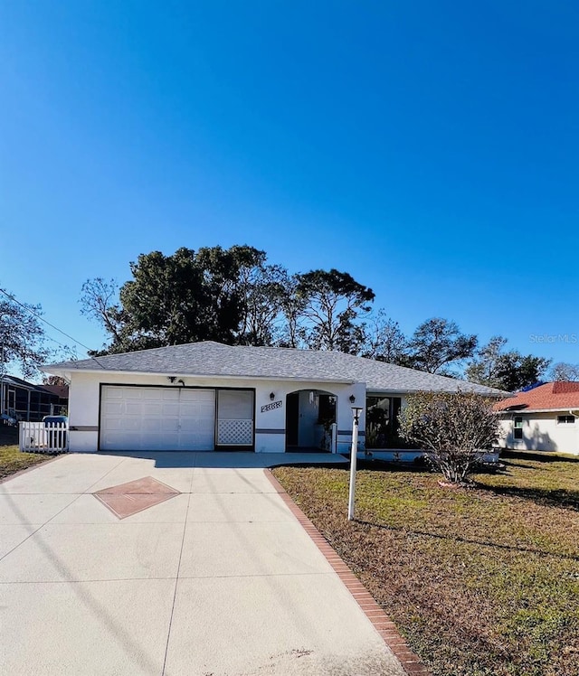 ranch-style house featuring a garage and a front lawn