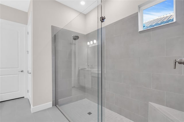 bathroom with tile patterned floors and tiled shower