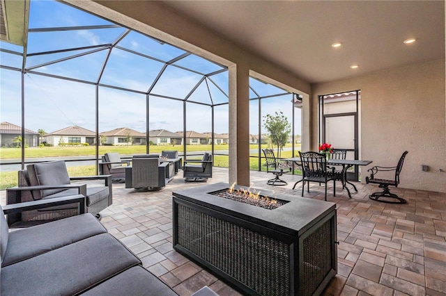 view of patio featuring a lanai and an outdoor living space with a fire pit